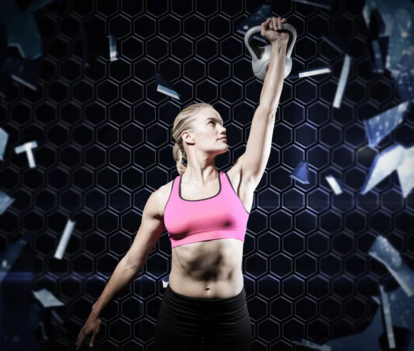 Gespierde vrouw hijs zware kettlebell — Stockfoto