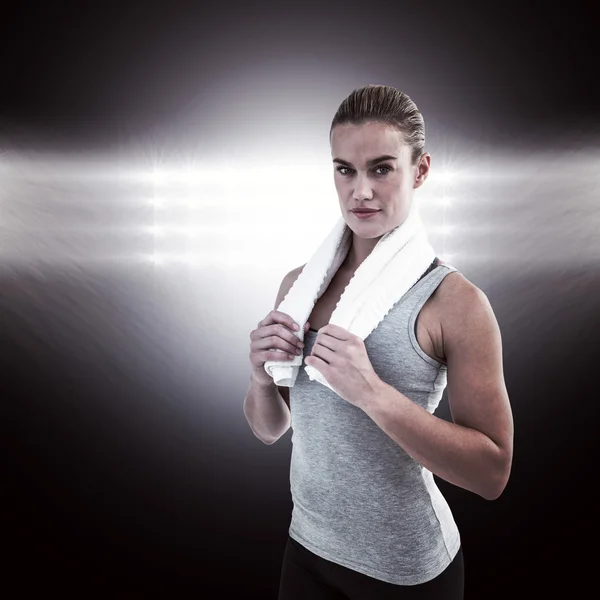 Muscular woman holding a towel around her neck — Stock Photo, Image