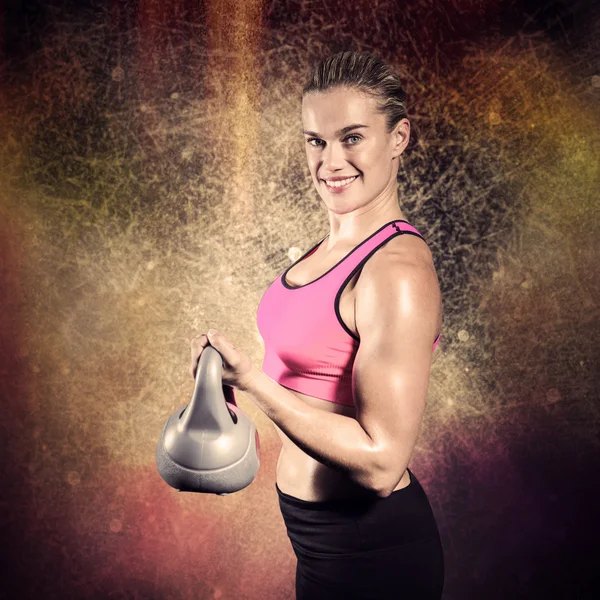 Mulher muscular levantando kettlebell pesado — Fotografia de Stock