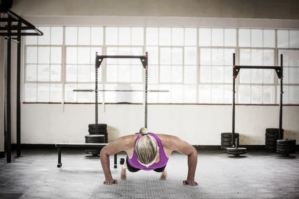 Muskulös kvinna göra push ups — Stockfoto