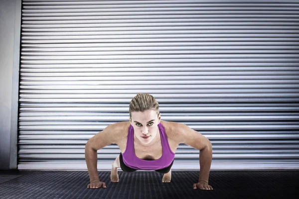 Muscular woman doing push ups — Stock Photo, Image