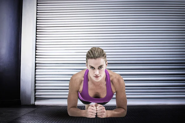 Muscular woman doing push ups — Stock Photo, Image