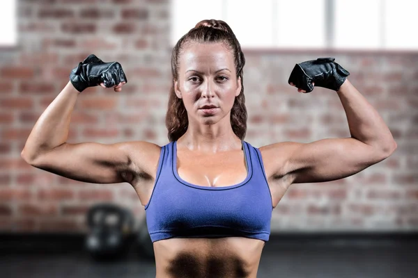 Portrait of woman with gloves flexing muscles — Stock Photo, Image