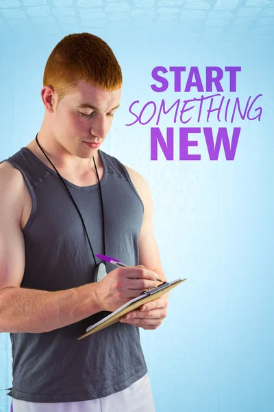 Fit personal trainer writing on clipboard — Stock Photo, Image