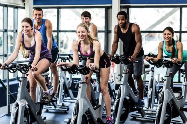 Fit people working out at spinning class clipart