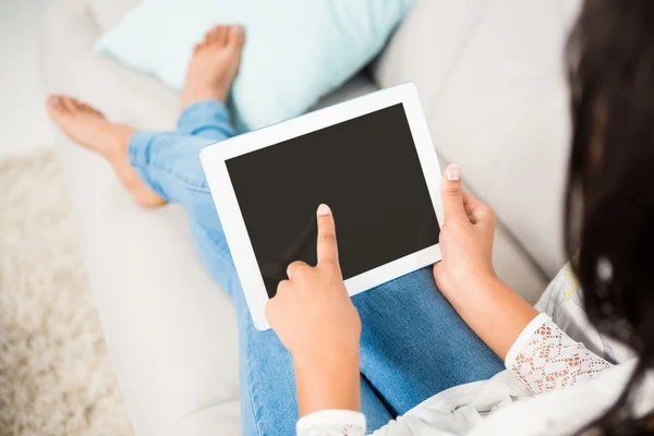 Vrouw met behulp van de tablet op de Bank — Stockfoto