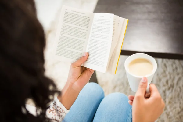 Mulher segurando xícara de café e livro — Fotografia de Stock