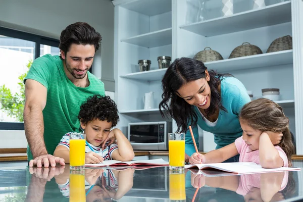 Pais ajudando seus filhos fazendo lição de casa — Fotografia de Stock