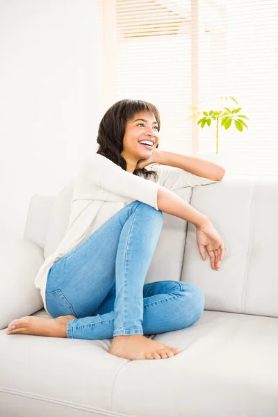 Ładna kobieta uśmiechając się na kanapie — Zdjęcie stockowe