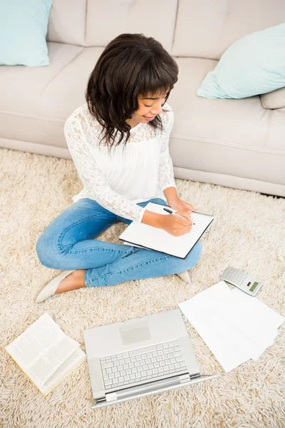 Mujer casual escribiendo notas mientras utiliza el ordenador portátil — Foto de Stock