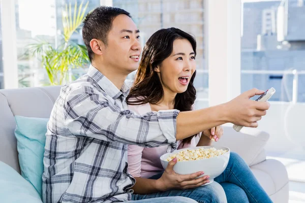 Fröhliches junges Paar sitzt auf Sofa — Stockfoto