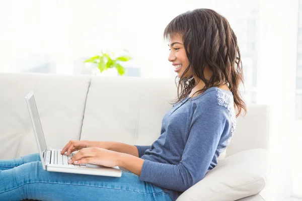 Випадкова усміхнена жінка використовує ноутбук — стокове фото