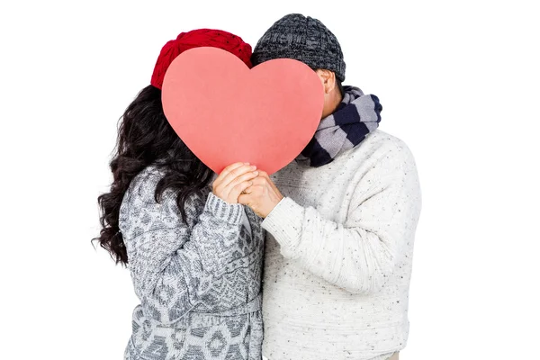 Couple hiding behind heart shape cardboard — Stock Photo, Image