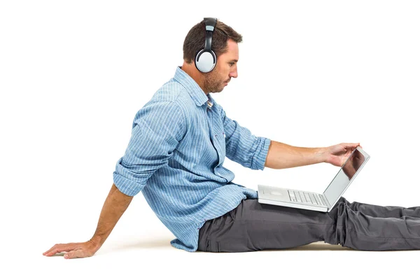 Hombre usando portátil y auriculares —  Fotos de Stock