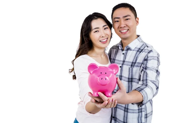 Vrolijke paar bedrijf piggy bank — Stockfoto