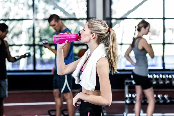 Blonde vrouw drinkbaar water na het sporten — Stockfoto
