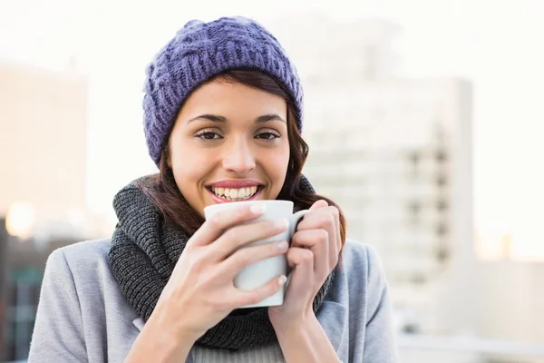 Smiling woman drinking hot beverage — Stock Photo, Image