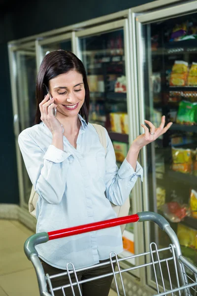 Wanita tersenyum di telepon di lorong — Stok Foto