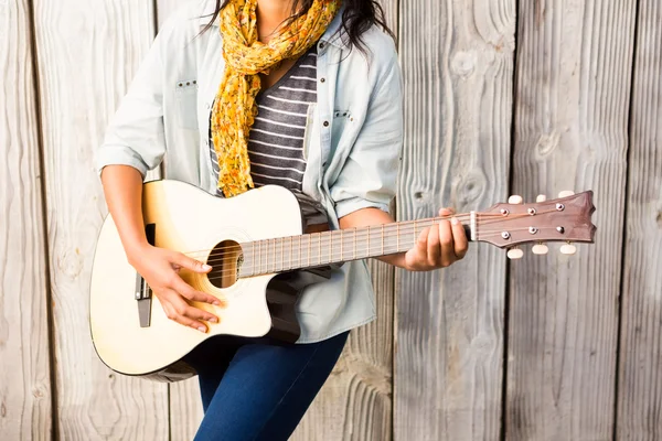 Улыбающаяся женщина, играющая на гитаре — стоковое фото