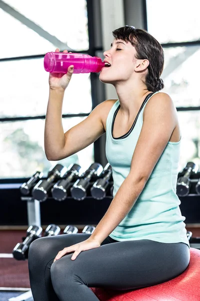 Διψασμένος γυναίκα πόσιμο νερό την μπάλα γυμναστικής — Φωτογραφία Αρχείου