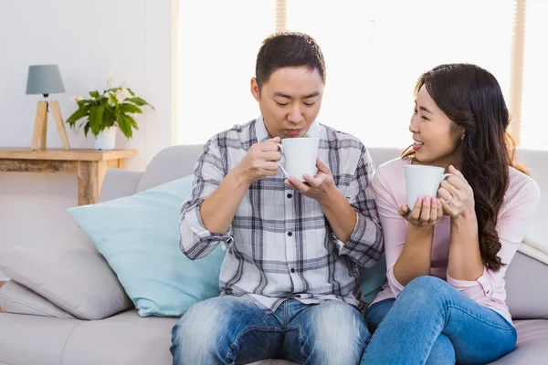 Glückliche Frau schaut Mann an, während sie Kaffeetasse hält — Stockfoto
