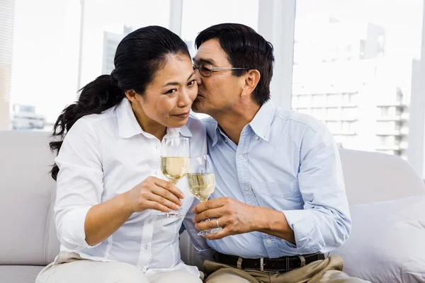 Mann küsst Frau mit Weinglas — Stockfoto