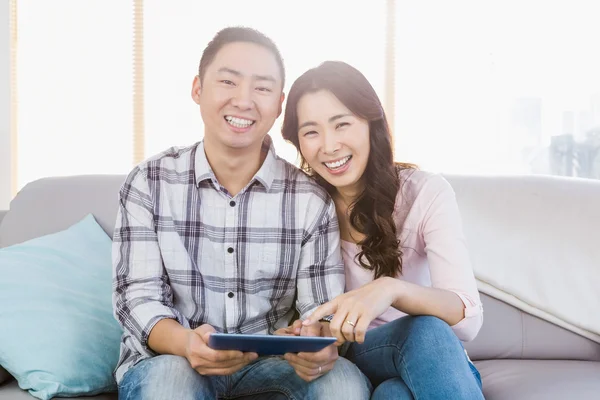 Jovem casal feliz segurando tablet digital — Fotografia de Stock