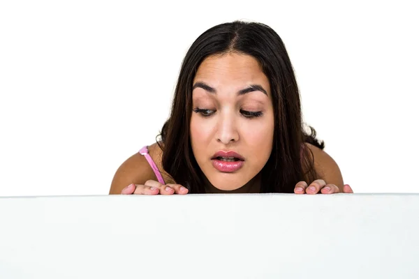 Woman peeking against white background — Stock Photo, Image