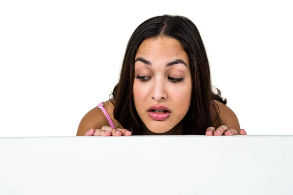 Vrouw gluren tegen witte achtergrond — Stockfoto