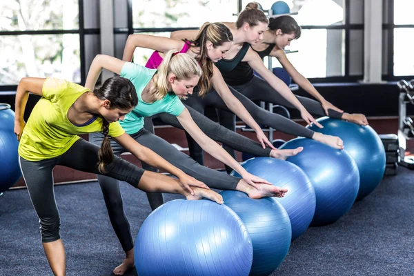 Fit sorrindo grupo fazendo exercício com bolas de exercício — Fotografia de Stock