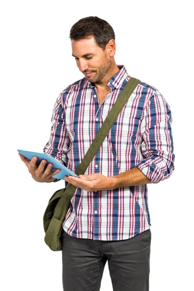 Homem sorridente com bolsa de ombro usando tablet — Fotografia de Stock