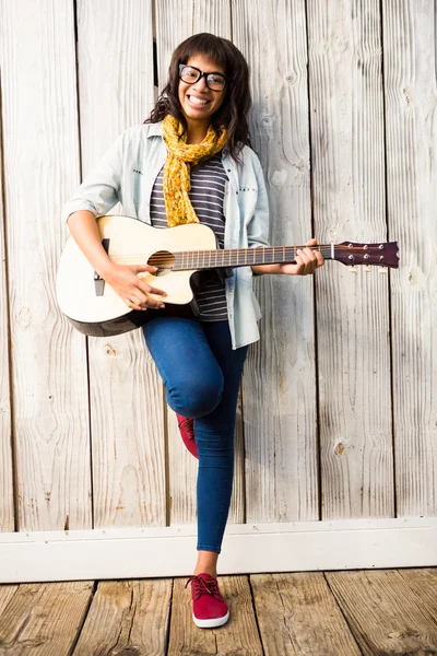 Улыбающаяся женщина, играющая на гитаре — стоковое фото