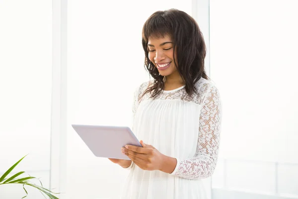 Lachende vrouw met behulp van haar tablet in woonkamer — Stockfoto