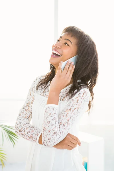 Uśmiechnięta kobieta mając telefon w salonie — Zdjęcie stockowe