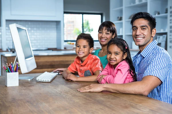 Happy family using computer in the kitchen — Stock Photo, Image