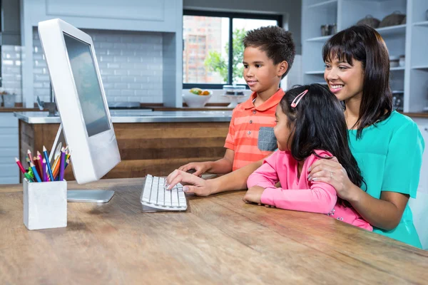 Madre feliz usando la computadora con sus hijos —  Fotos de Stock