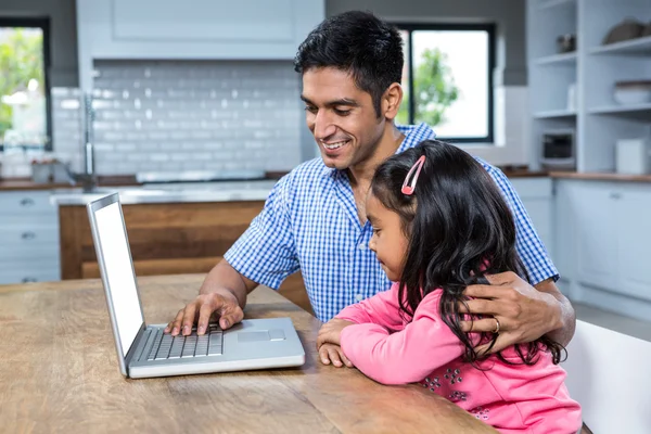 微笑着的父亲与他的女儿使用笔记本电脑 — 图库照片