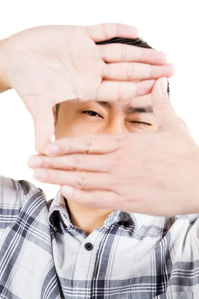 Portrait of man looking through finger frame — Stock Photo, Image