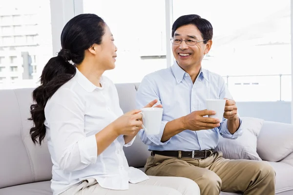 Couple enjoying coffee on the couch — Stock Photo, Image