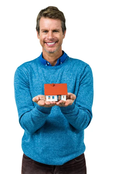 Προσωπογραφία άνδρα χαμογελώντας κρατώντας μοντέλο σπίτι — Φωτογραφία Αρχείου