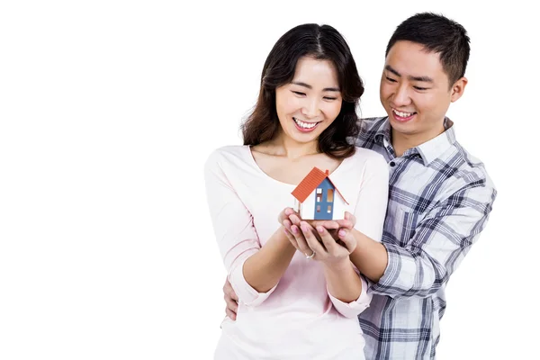 Casal feliz segurando uma casa modelo — Fotografia de Stock