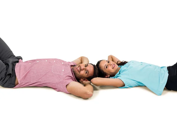 Smiling couple laying on floor with hands — Stock Photo, Image