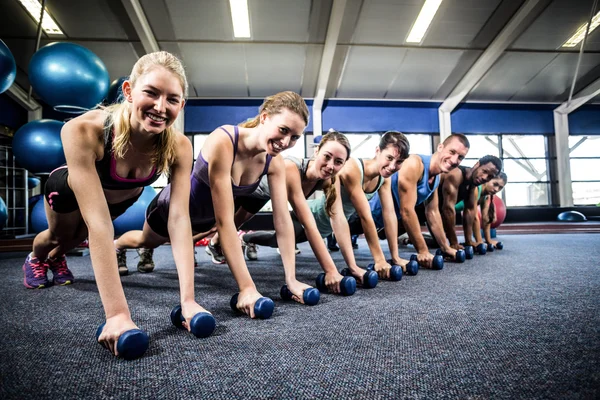 Clase de fitness en posición de tablón con mancuernas — Foto de Stock