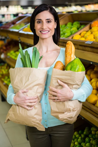 Donna sorridente che tiene la borsa della spesa — Foto Stock