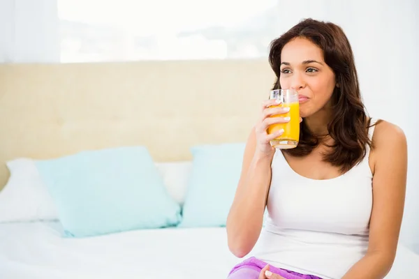 Mulher feliz segurando vidro de suco de laranja — Fotografia de Stock