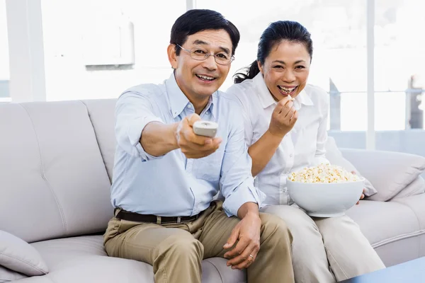 Uomo e donna sorridenti seduti sul divano — Foto Stock