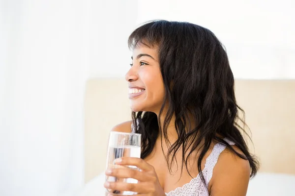 Casual lachende vrouw met een glas water — Stockfoto