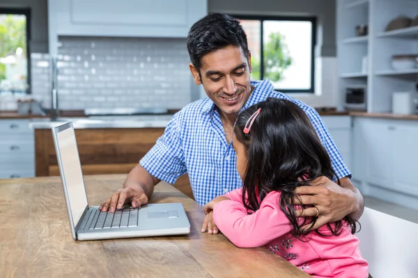 微笑着的父亲与他的女儿使用笔记本电脑 — 图库照片