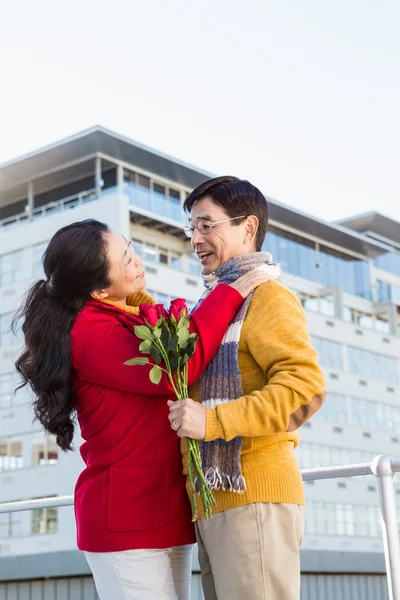 Anziani coppia asiatica sul balcone con rose — Foto Stock