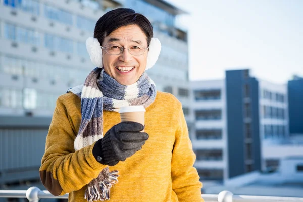 Older asian man with coffee to go